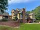 Rear exterior view of a two-story home featuring a brick retaining wall and wooden patio at 1695 Whitley Rd, Dacula, GA 30019