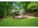 A charming backyard with a patio, fire pit area, and tiered landscaping, perfect for outdoor gatherings at 3726 Scotts Mill Run, Peachtree Corners, GA 30096