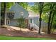 Two-story home with stone accents and a stairway leading to the entrance, nestled on a lot with mature trees at 3726 Scotts Mill Run, Peachtree Corners, GA 30096