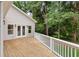 Wide back porch with white railings offers a view of the treed property and access through glass doors at 1036 Dell Se Ave, Smyrna, GA 30080