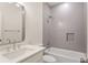Modern bathroom features gray tiled shower and tub, white countertop and sink, and a rectangular mirror at 1036 Dell Se Ave, Smyrna, GA 30080