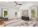 Staged primary bedroom with white walls, wood floors, ceiling fan, and deck access at 1036 Dell Se Ave, Smyrna, GA 30080