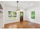 Bright dining room features hardwood floors, modern chandelier and a large window overlooking the front yard at 1036 Dell Se Ave, Smyrna, GA 30080