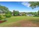 A lush green backyard with mature trees, lawn, and seating areas on a sunny day at 1335 Seneca, Cumming, GA 30041