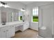 Bright bathroom with double sinks, vanity, walk-in shower, and view to lawn at 1335 Seneca, Cumming, GA 30041