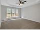 Bright carpeted bedroom with a ceiling fan and multiple windows overlooking the backyard at 1335 Seneca, Cumming, GA 30041