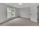Carpeted bedroom with natural light from a window, and an open door to a hallway at 1335 Seneca, Cumming, GA 30041