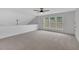 Open bonus room with large windows, neutral walls and carpet, and ceiling fan at 1335 Seneca, Cumming, GA 30041