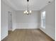 Bright dining room featuring wood floors, a modern chandelier, and elegant white wainscoting at 1335 Seneca, Cumming, GA 30041