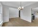 Dining room with a view into the kitchen, featuring wood floors, modern chandelier, and white wainscoting at 1335 Seneca, Cumming, GA 30041