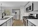 Modern kitchen with stainless steel appliances, gray cabinetry, and white countertops at 1335 Seneca, Cumming, GA 30041