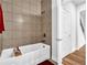 Bathtub and shower with tiled walls and hardwood flooring at 307 Ernest Ave, Peachtree City, GA 30269