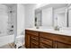 Bathroom featuring double sinks with a wood vanity, a large mirror, and a bathtub with a shower at 307 Ernest Ave, Peachtree City, GA 30269