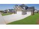 Large driveway leading to a two-story home with a stone and vinyl facade and a 3-car garage at 307 Ernest Ave, Peachtree City, GA 30269
