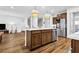 Open concept kitchen with island seating, stainless appliances, pendant lights, and hardwood floors at 307 Ernest Ave, Peachtree City, GA 30269