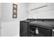 Modern laundry room featuring black appliances and minimalist décor at 307 Ernest Ave, Peachtree City, GA 30269