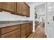 Walk-in pantry with granite countertops, warm brown cabinetry, and an open doorway at 307 Ernest Ave, Peachtree City, GA 30269