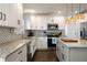 Modern kitchen boasting white cabinetry, granite countertops, stainless appliances, and stylish backsplash at 3412 Orchard St, Atlanta, GA 30354