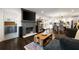 Open-concept living room featuring a cozy fireplace, hardwood floors, and seamless flow to dining area at 3412 Orchard St, Atlanta, GA 30354