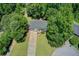 Aerial view of the property shows a home with a driveway and lush surroundings of mature trees at 407 Yellowstone Dr, Powder Springs, GA 30127