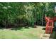 Expansive backyard features lush lawn, mature trees, and a wooden deck with stairs, perfect for outdoor living at 407 Yellowstone Dr, Powder Springs, GA 30127