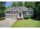 Charming home featuring a manicured lawn, two-car garage, and classic architectural details at 407 Yellowstone Dr, Powder Springs, GA 30127