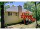 Rear exterior view of home showcases a deck with stairs, surrounded by a lush, green backyard at 407 Yellowstone Dr, Powder Springs, GA 30127