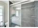 Modern bathroom featuring a tiled shower with a glass door, plus a dual sink vanity and window for natural light at 407 Yellowstone Dr, Powder Springs, GA 30127