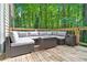 Comfortable outdoor sectional with coffee table on spacious wooden deck with wooded view at 2435 Roxburgh Dr, Roswell, GA 30076
