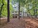Exterior backyard view of house and deck surrounded by mature trees at 2435 Roxburgh Dr, Roswell, GA 30076