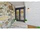 Elegant double doors framed by stone and siding with potted plants and wreaths at 2435 Roxburgh Dr, Roswell, GA 30076