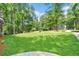 Large, manicured front yard with lush green grass and trees in a residential neighborhood at 2435 Roxburgh Dr, Roswell, GA 30076