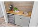 Wet bar with butcher block countertop, wine fridge, and wooden accent wall at 2435 Roxburgh Dr, Roswell, GA 30076