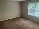Bright bedroom featuring a large window and neutral walls with carpeted flooring at 4963 Windsor Downs Ln, Decatur, GA 30035