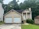 Traditional two-story home with a two car garage, well-maintained lawn, and mature trees at 4963 Windsor Downs Ln, Decatur, GA 30035