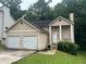 Two-story home with attached two-car garage, front porch with columns, and neutral siding at 4963 Windsor Downs Ln, Decatur, GA 30035