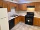 Kitchen with wooden cabinets, a black range, a dishwasher, and a double sink at 4963 Windsor Downs Ln, Decatur, GA 30035