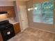 Functional kitchen with wooden cabinets, black appliances, and a window over the sink at 4963 Windsor Downs Ln, Decatur, GA 30035
