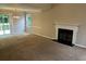 Spacious living room featuring a fireplace, neutral carpet, and sliding glass doors to a deck at 4963 Windsor Downs Ln, Decatur, GA 30035