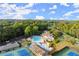Scenic aerial view of the community pool, tennis courts, clubhouse, and lush greenery under a blue sky at 979 Pathview Ct, Dacula, GA 30019