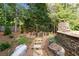 Backyard with raised garden beds, a stone fireplace, stone path, and ample landscaping at 979 Pathview Ct, Dacula, GA 30019