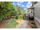 Backyard with a deck, lush lawn, landscaping, and a brick exterior, leading to a patio at 979 Pathview Ct, Dacula, GA 30019
