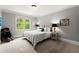 Neutral bedroom with a cozy carpet, large window, and a comfortable bed with side tables and lamps at 979 Pathview Ct, Dacula, GA 30019