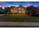 Charming two-story brick home with manicured lawn and mature trees at twilight at 979 Pathview Ct, Dacula, GA 30019