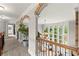 Hallway with carpeted floors and wooden railings overlooking the living room with arched windows at 979 Pathview Ct, Dacula, GA 30019