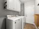 Laundry room with tile floor, washer and dryer hookups, and white cabinets at 979 Pathview Ct, Dacula, GA 30019