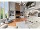 Elegant living room featuring hardwood floors, stone fireplace, large windows, and custom built-ins at 979 Pathview Ct, Dacula, GA 30019