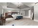 Spacious main bedroom featuring a tray ceiling, neutral tones, carpet, and a decorative chandelier at 979 Pathview Ct, Dacula, GA 30019