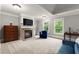 Bright main bedroom showcasing a fireplace, TV, and large windows overlooking the backyard at 979 Pathview Ct, Dacula, GA 30019