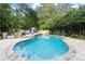 Outdoor pool with stone patio featuring a fireplace and lush greenery at 979 Pathview Ct, Dacula, GA 30019